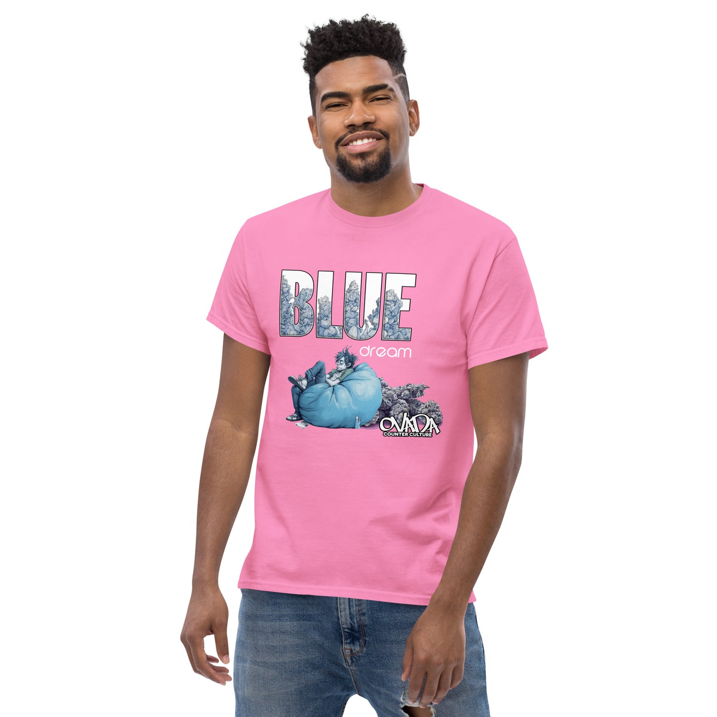 A man in a pink cotton graphic t-shirt with the words Blue Dream. A monochromatic blue cartoon depiction of a stoner passed out in a bean back with marijuana buds behind him. Ganja.