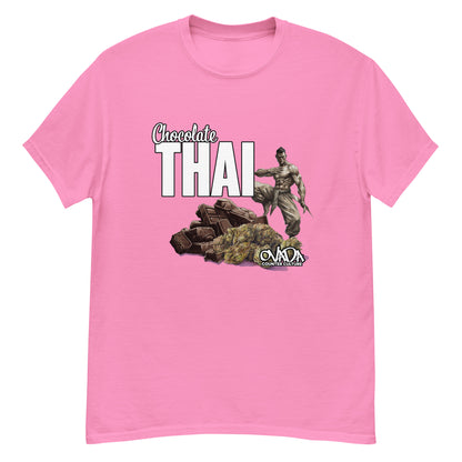 A pink cotton graphic t-shirt with the words Chocolate Thai. A cartoon depiction of a Muay Thai Fighter is standing on a pile of chocolates, with marijuana buds in front of it. 