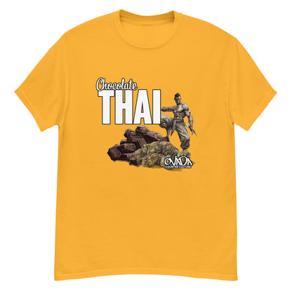 A gold yellow cotton graphic t-shirt with the words Chocolate Thai. A cartoon depiction of a Muay Thai Fighter is standing on a pile of chocolates, with marijuana buds in front of it. 