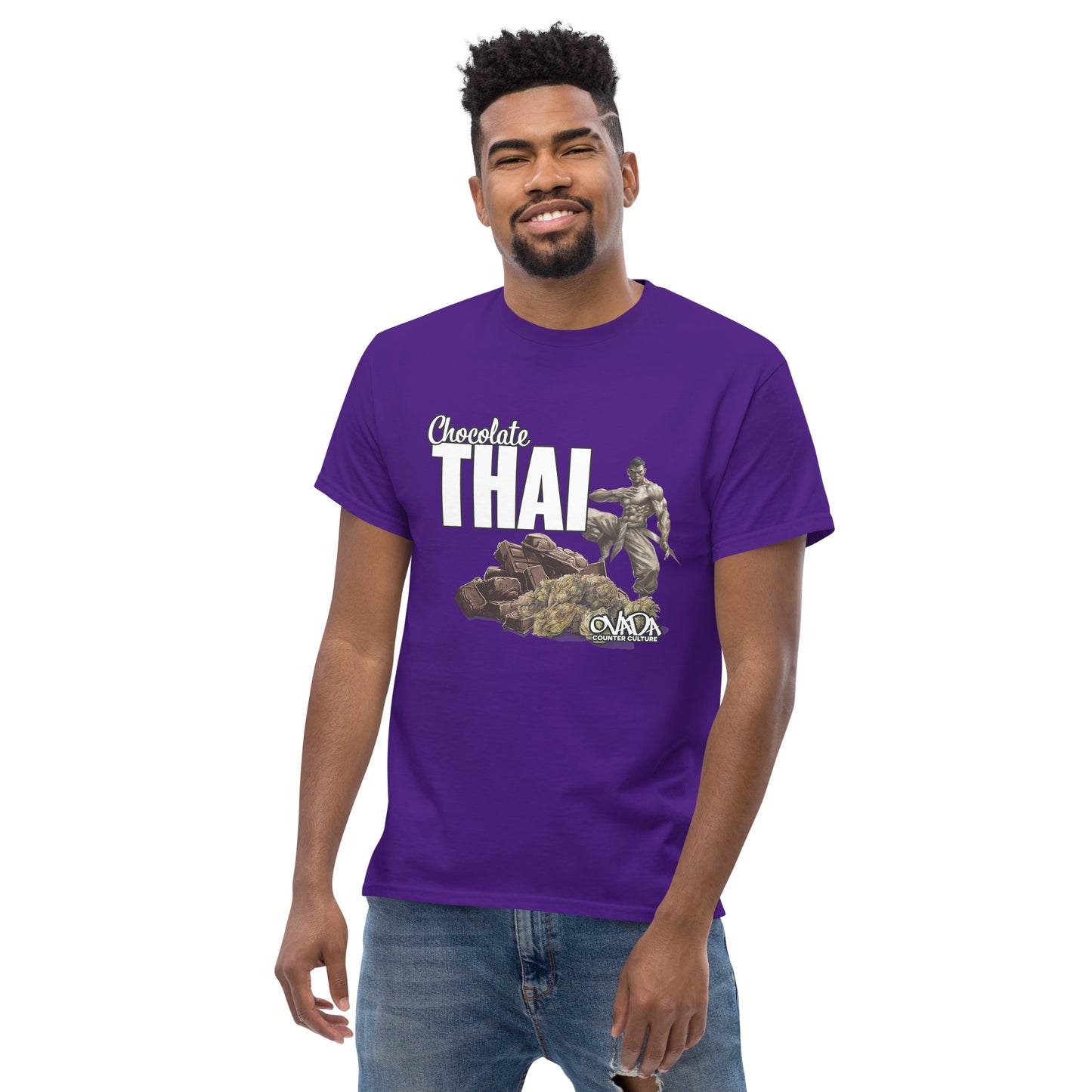 A man in a purple cotton graphic t-shirt with the words Chocolate Thai. A cartoon depiction of a Muay Thai Fighter is standing on a pile of chocolates, with marijuana buds in front of it. 