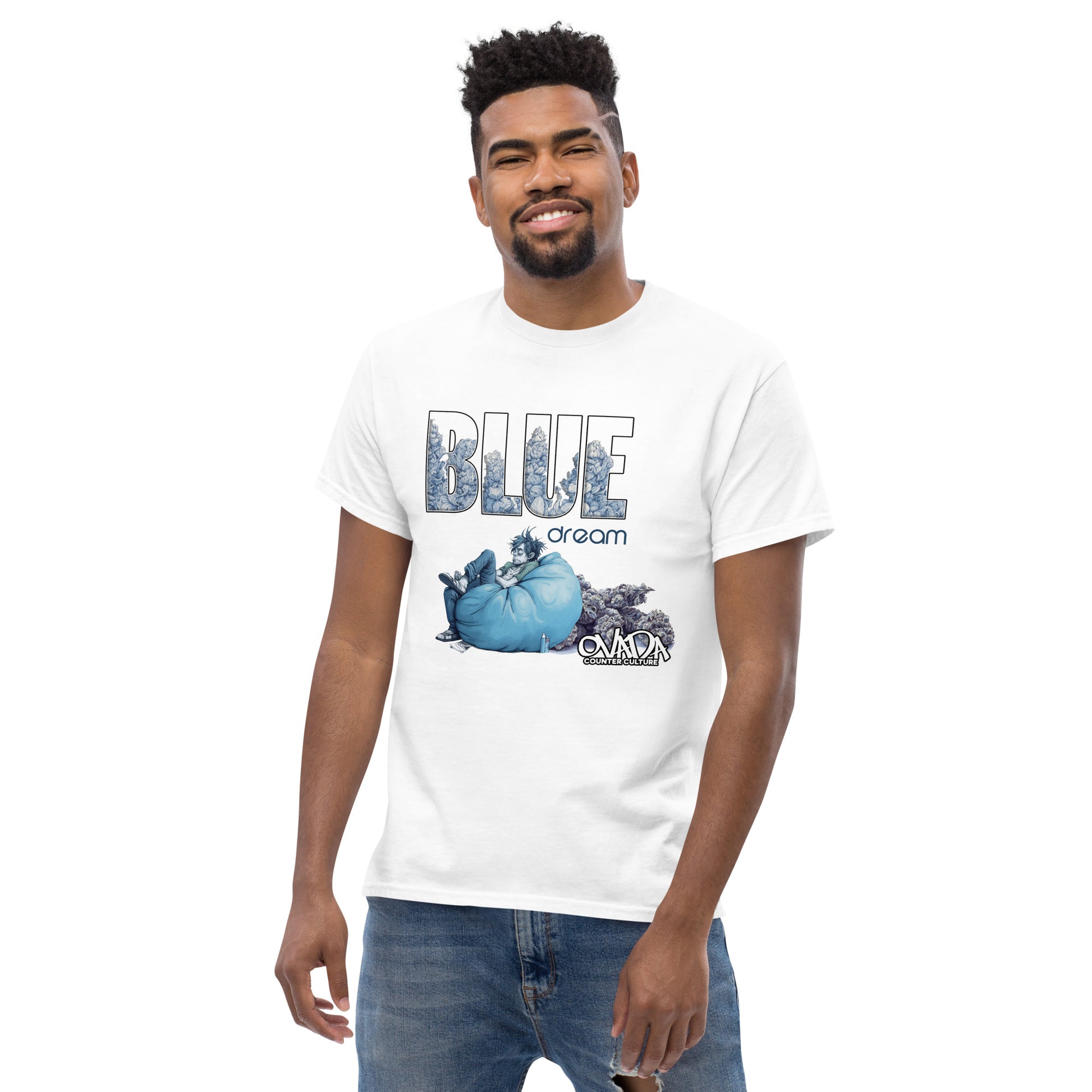 A man in a white cotton graphic t-shirt with the words Blue Dream. A monochromatic blue cartoon depiction of a stoner passed out in a bean back with marijuana buds behind him. Weed